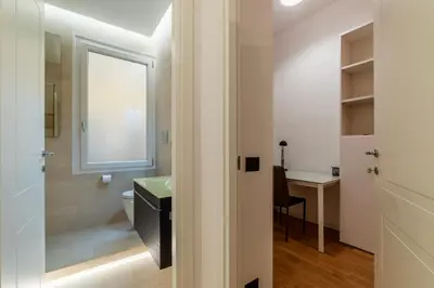 a bathroom with a sink and a toilet and a desk at GuestHost - Piazza Bologna Sweet Apartment in Rome