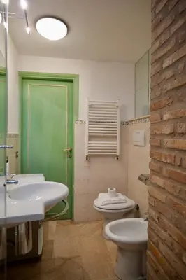 a bathroom with a green door and a toilet and sink at Fororomano Luxury in Rome