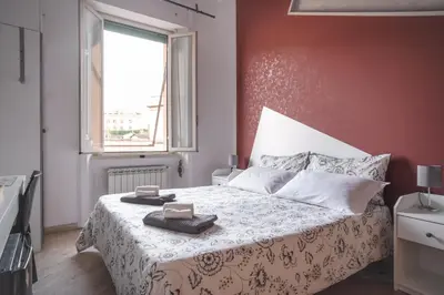 a bedroom with a bed with a white blanket and a window at B&B Vatican Stories in Rome
