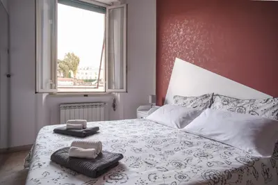 a bedroom with a bed with two towels and a window at B&B Vatican Stories in Rome