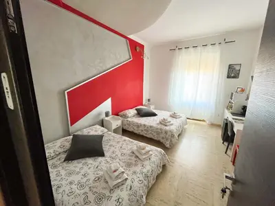 a bedroom with two beds and a red wall at B&B Vatican Stories in Rome