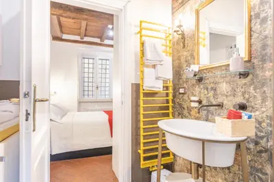 a bathroom with a sink and a yellow ladder at AC21 - Palazzetto Campo de' Fiori in Rome