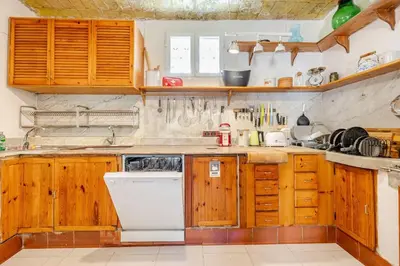 a kitchen with wooden cabinets and a white dishwasher at Riad Riari in Rome