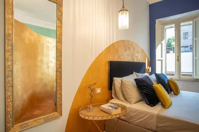 a living room with a blue couch and a kitchen at PgrHome Colosseo 11 BLU in Rome