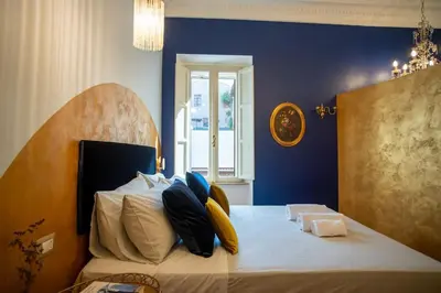 a bedroom with a large white bed with yellow and blue pillows at PgrHome Colosseo 11 BLU in Rome