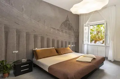 a bedroom with a large bed with a mural on the wall at San Pietro Guest House in Rome