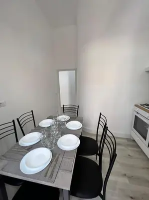 a dining room table with white plates and chairs at Campo de’ Fiori Rooftop Apartment in Rome