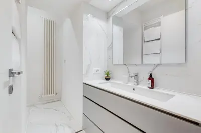 a white bathroom with a sink and a mirror at Opera Exclusive House by Premium Suites Collection in Rome