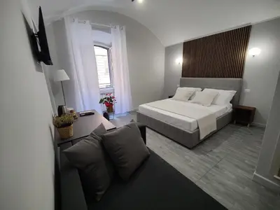 a bedroom with a bed and a couch at Holiday 168 Guest House in Rome