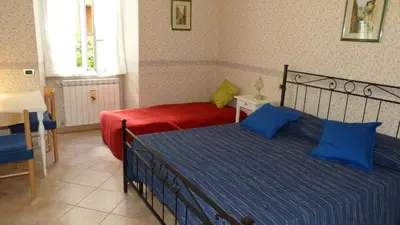 a bedroom with two beds with blue and red sheets at Rossanella House in Rome