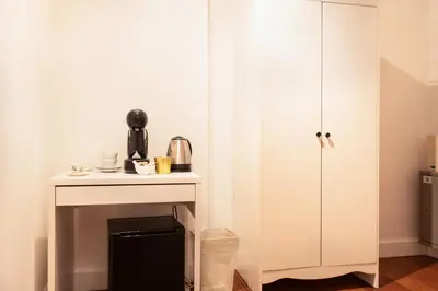 a kitchen with a white cabinet next to a table at Charme & Chic San Giacomo in Rome