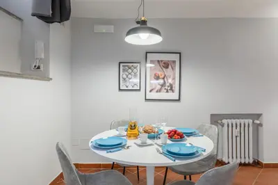 a white dining room with a white table and chairs at Dolce Vita Dreaming Studio in Rome