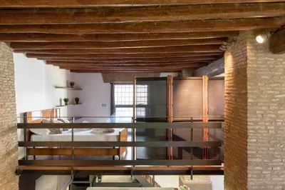 a room with a staircase and a brick wall at Santa Cecilia Loft in Rome