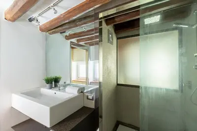 a bathroom with a white sink and a glass shower at Santa Cecilia Loft in Rome