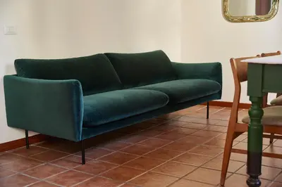 a green couch sitting in a living room at TrastevereHome - Santa Maria della Quercia in Rome