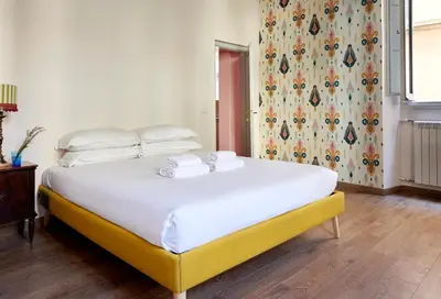 a bedroom with a large white bed with a yellow frame at TrastevereHome - Santa Maria della Quercia in Rome