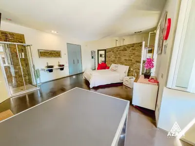 a bedroom with a bed and a brick wall at Azadi Suite Flaminio in Rome