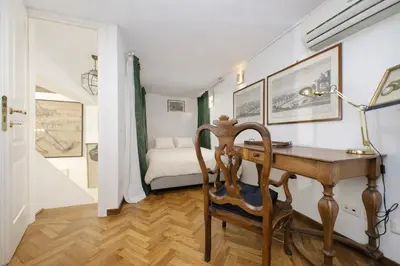 a room with a desk with a bed in the background at On The Steps in Rome