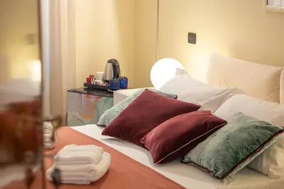 a bed with several pillows on it with a mirror at TimeRoma Vatican in Rome