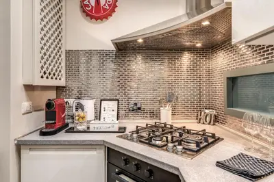 a kitchen with a stove top oven next to a counter at Daag Corso Luxury Apartment in Rome