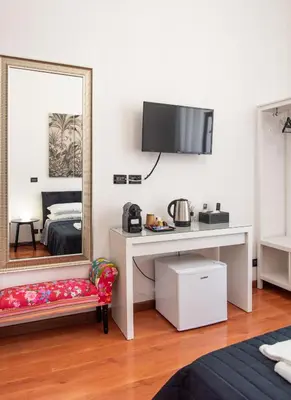 a bedroom with a mirror and a desk and a bed at Pura Vida in Rome
