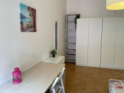 a kitchen with white cabinets and a pink kettle on a table at Group Apartment Roma in Rome