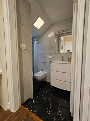 a bathroom with a sink and a toilet and a mirror at THE ONE FRATTINA Apartment in Rome