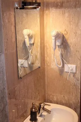 a bathroom with a sink and two hair dryers on the wall at Roma Art Rooms in Rome