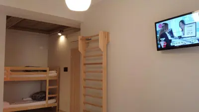 a bedroom with bunk beds and a flat screen tv on the wall at Roma Art Rooms in Rome