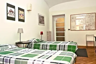 two beds in a room with green and white sheets at Minerva House in Rome