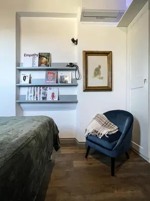 a bedroom with a bed and a blue chair at DomusLu' - Casa di charme nel cuore di Roma in Rome
