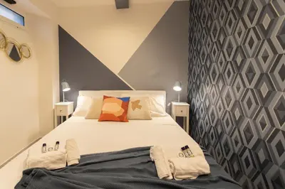 a bedroom with a large white bed with pillows at Nina - Tiny Suite in Trastevere in Rome