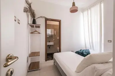 a white room with a bed and a mirror at The Best Rent - Bright flat near San Pietro in Rome