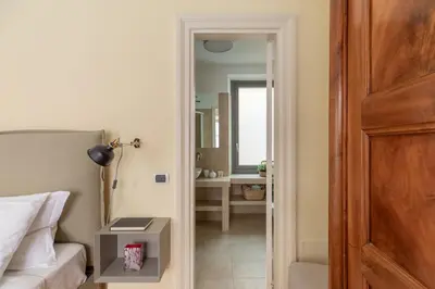 a bedroom with a bed and a door leading to a bathroom at iFlat Little & Bright in Trevi in Rome
