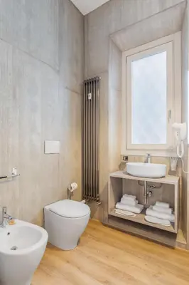 a bathroom with a toilet and a sink and a window at Adelante rooms Piazza Bologna in Rome