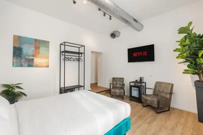 a bedroom with a bed and two chairs and a tv at Adelante rooms Piazza Bologna in Rome