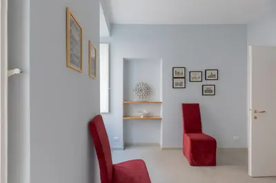 a living room with two red chairs and a table at iFlat Lovely in Trevi in Rome