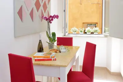 a dining room with a table and red chairs at NuvolHouse in Rome