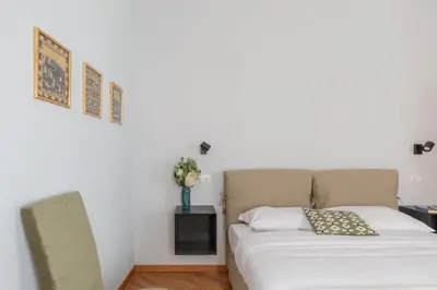 a bed in a room with a white wall at iFlat Trevi Charming in Rome