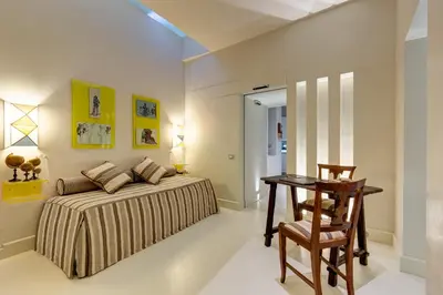 a bedroom with a bed and a table and a chair at Domus Domitia Luxury Living in Rome