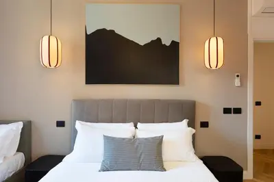 a bedroom with a bed with two lights above it at ROMAC Trinity with steam bath in Rome