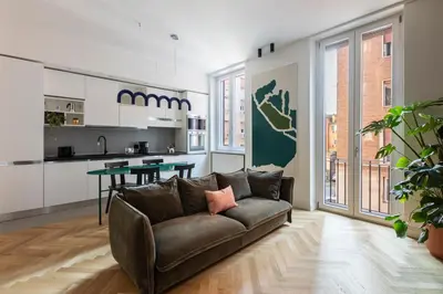 a living room with a couch and a kitchen at ROMAC Trinity with steam bath in Rome