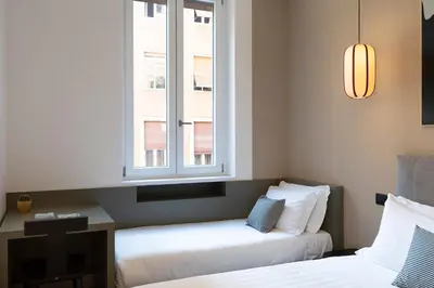 two beds in a room with a window at ROMAC Trinity with steam bath in Rome