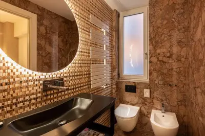 a bathroom with a sink and a toilet and a mirror at ROMAC Trinity with steam bath in Rome