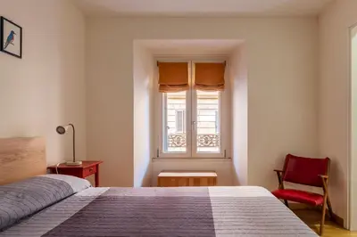 a bedroom with a bed and a window and a chair at GuestHost - Roma Termini Comfy Apartment in Rome
