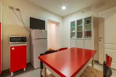 a kitchen with a red table and a refrigerator at GuestHost - Roma Termini Comfy Apartment in Rome