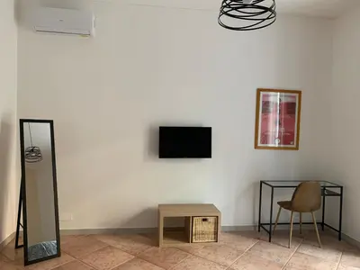 a room with a table and a television on a wall at CHEZ NOUS in Rome