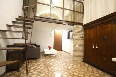 a living room with a staircase and a couch at Monti Holiday House in Rome