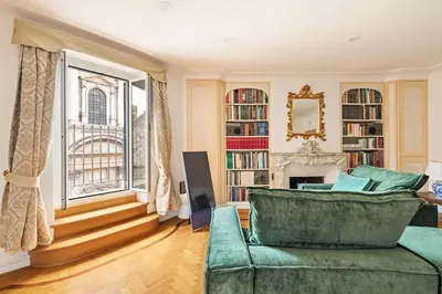 a living room with a green couch and a fireplace at Casa Colonna, a Burghesius home in Rome