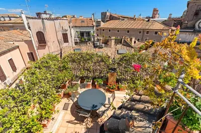 an overhead view of a courtyard with plants and a table at Casa Colonna, a Burghesius home in Rome